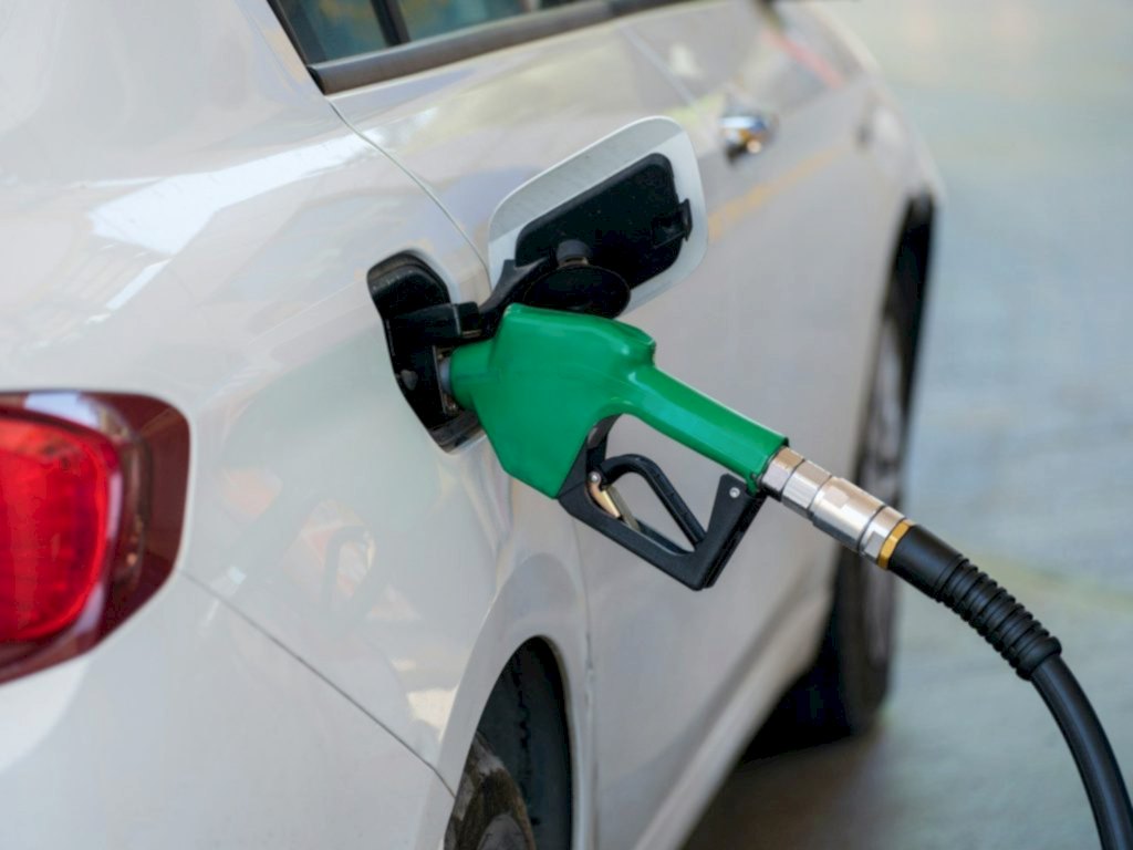 a white car with a green gas pump